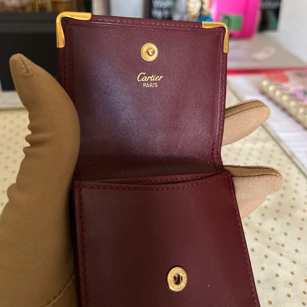 CARTIER small leather Coin purse with golden accents at top two corners.